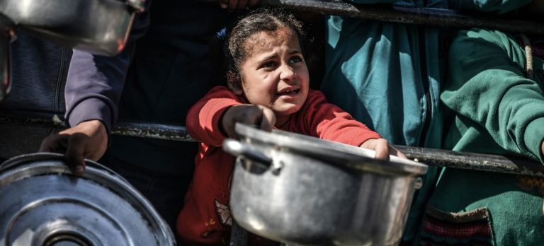 © UNICEF/Abed Zagout An 8-year-old child waits her turn to receive food in Rafah, in the southern Gaza Strip. (file)