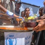 © WFP/Ali Jadallah غزہ میں عالمی پروگرام برائے خوراک کے تحت کام کرنے والے ایک کچن میں کھانا تقسیم کیا جا رہا ہے۔
