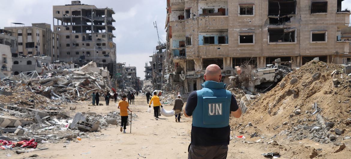 © UNOCHA/Themba Linden اقوام متحدہ کا ایک اہلکار بمباری سے متاثرہ خان یونس کے علاقے کا معائنہ کر رہا ہے۔