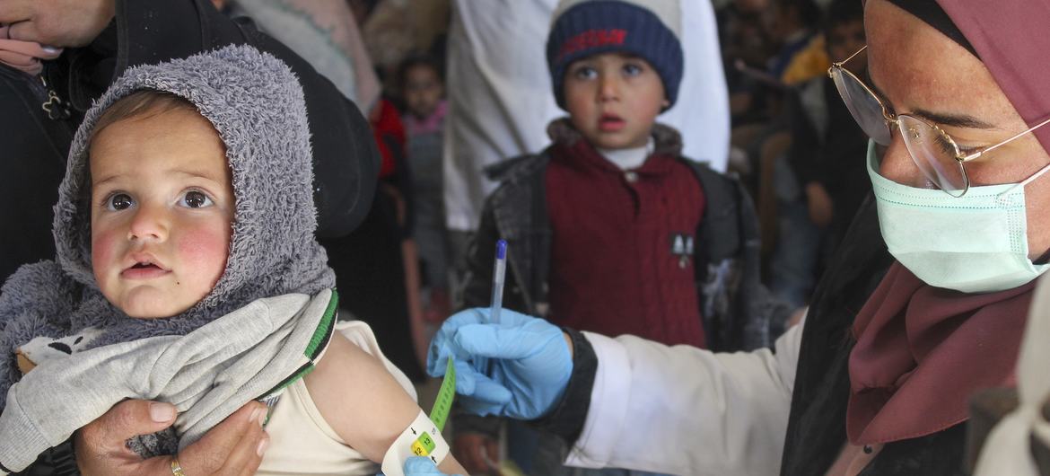 © UNICEF/Marissa Sargi شام میں یونیسف کی مدد سے کام کرنے والے ایک مرکز صحت پر غذائی قلت کے شکار بچے کا معائنہ کیا جا رہا ہے۔